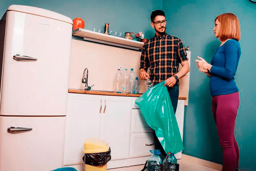 Pareja haciendo limpieza deshaciéndose de lo innecesario de su cocina