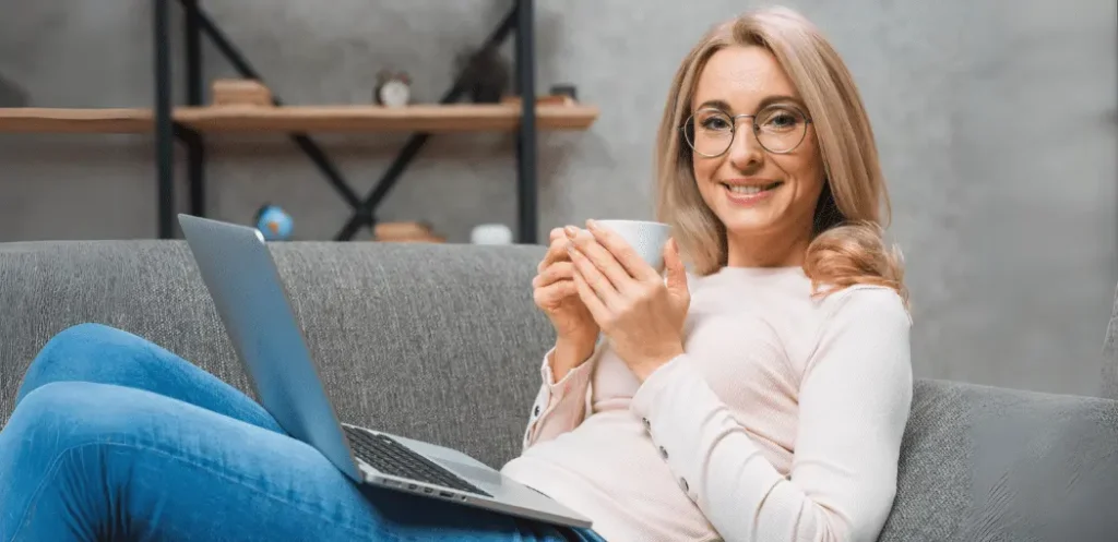 Mujer mayor con una taza de café mostrando uno de los beneficios de tomar café que es ser un aliado para la salud