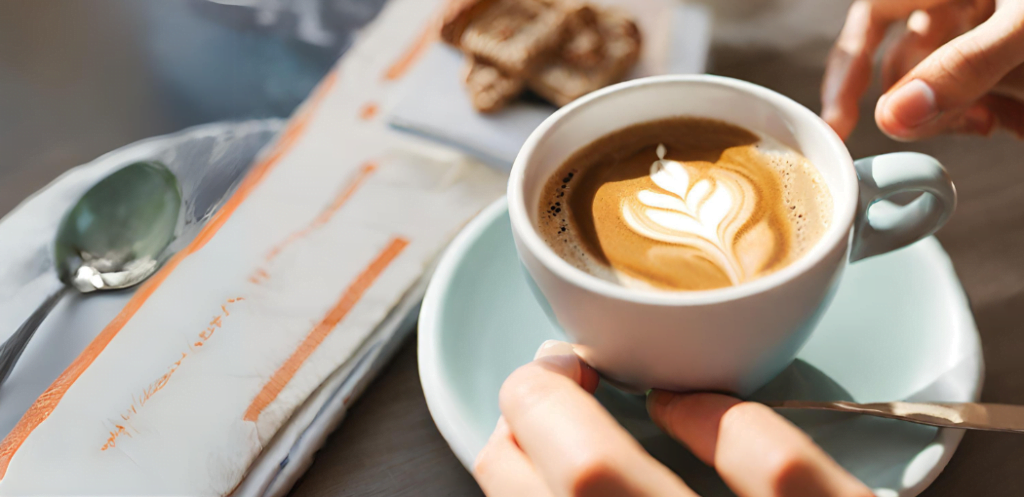 Taza de café latte mostrando uno de los beneficios de tomar café que es impulso mental y físico